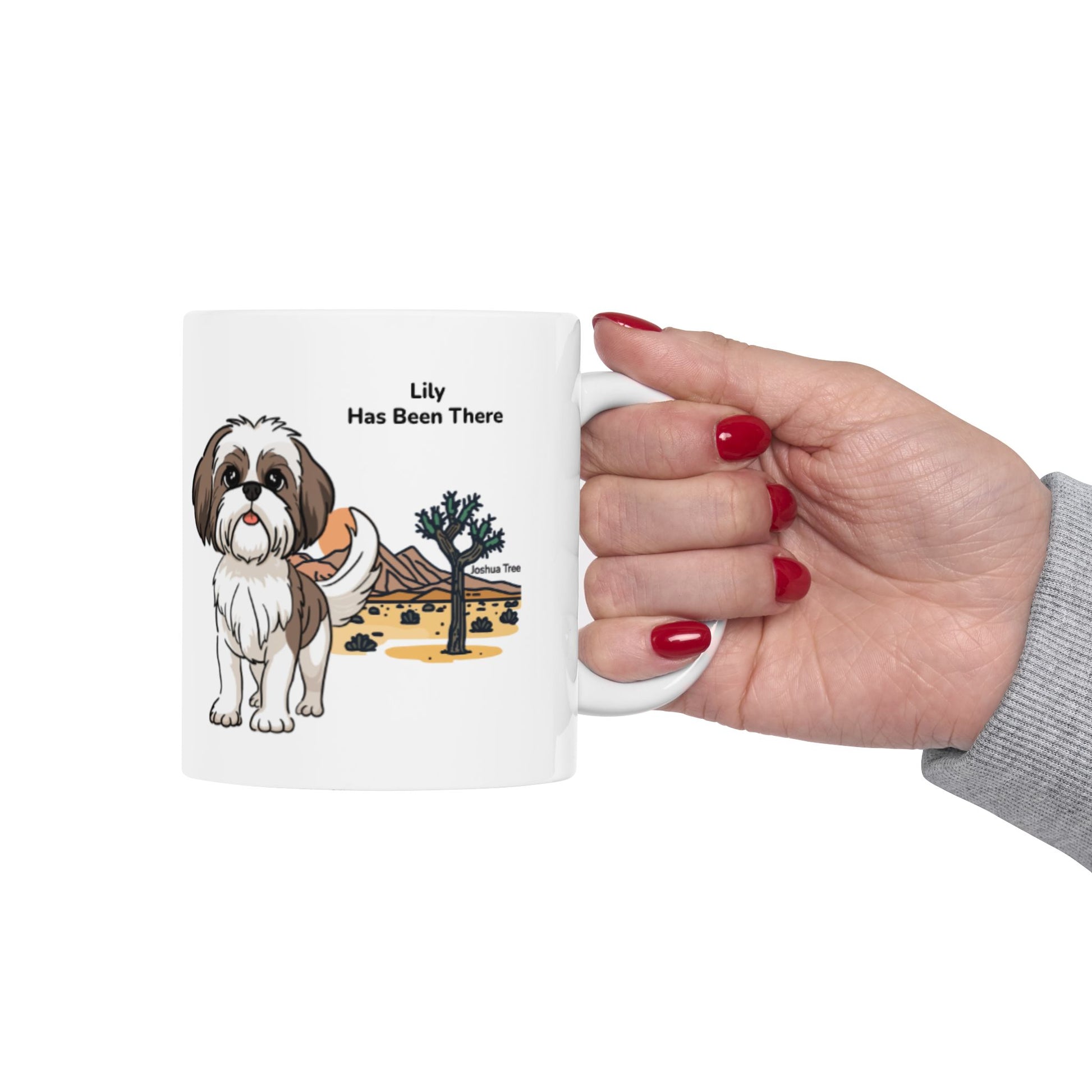 Hand holding a personalized mug, photographed from the right hand side with a dog illustration, dog name, "Has Been There" badge, and Joshua Tree national park illustration. National Park Series.