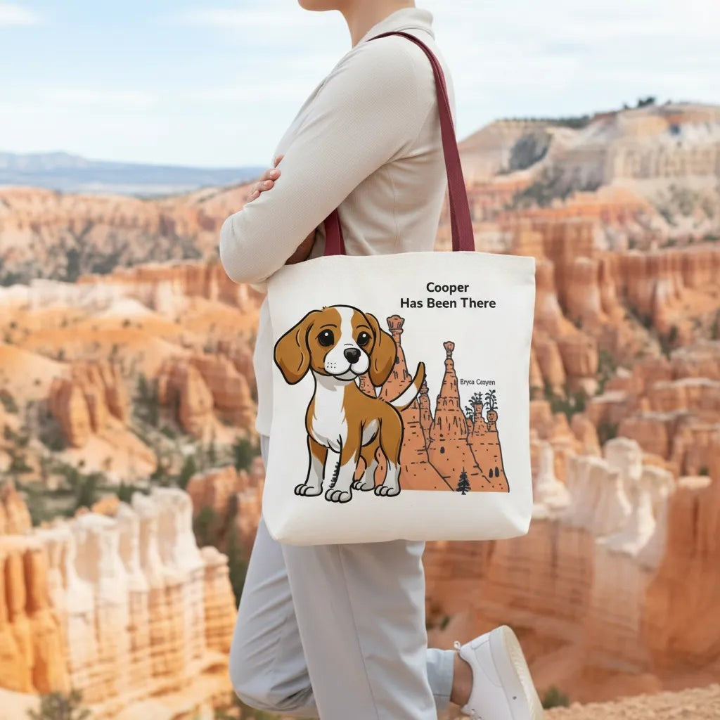 Person holding a personalized tote bag with a dog illustration, dog name, "Has Been There" badge, and Bryce Canyon illustration. National Park Series.